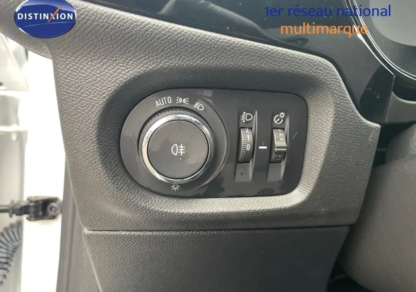 Gros plan sur le panneau de commande des phares à gauche du volant d'une Opel Corsa blanche 2022.