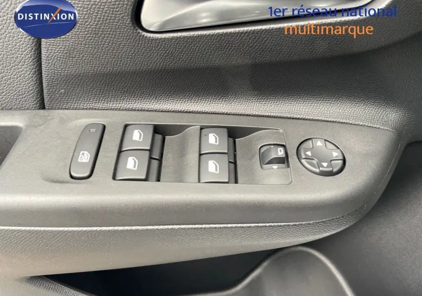 Gros plan sur les commandes de lève-vitres et réglages des rétroviseurs côté conducteur d'une Opel Corsa blanche 2022.