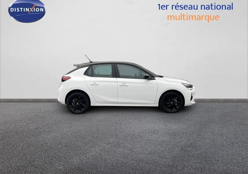 Profil droit d'une Opel Corsa blanche 5 portes avec jantes noires et toit contrasté noir sur fond neutre.