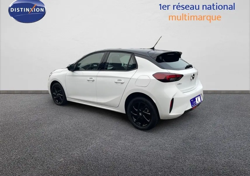 Opel Corsa blanc vue 3/4 arrière côté droit avec toit noir et jantes noires sur fond neutre.