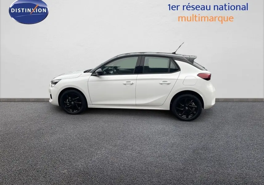 Profil droit d'une Opel Corsa blanche 2022 avec toit noir et jantes noires, sur fond neutre intérieur.