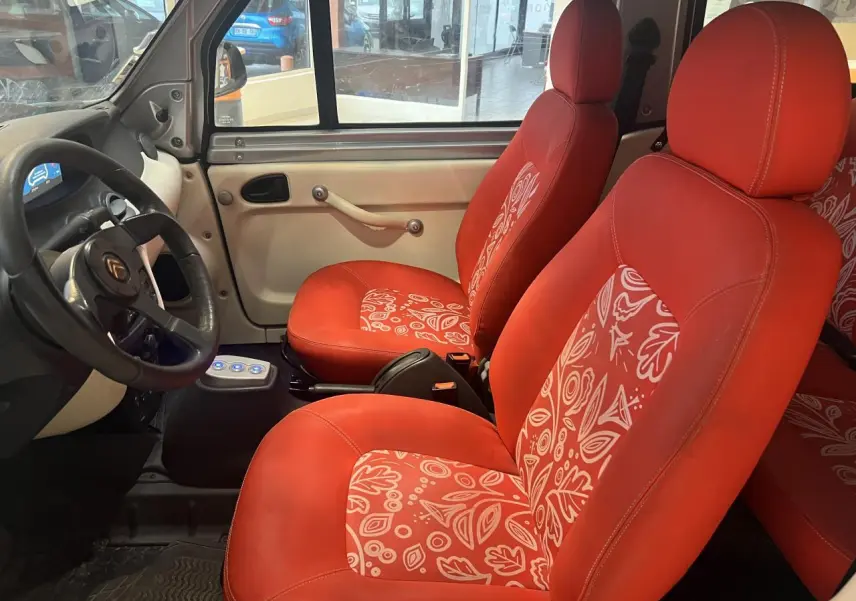 Intérieur avant du Citroën E-MEHARI cabriolet 2016, sièges rouges à motifs blancs et tableau de bord beige.