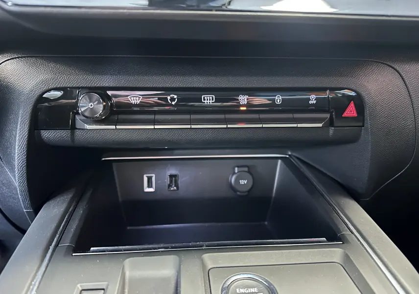 Vue rapprochée de la console centrale noire du Citroën C5 Aircross 2024 avec boutons de contrôle et prises USB visibles.