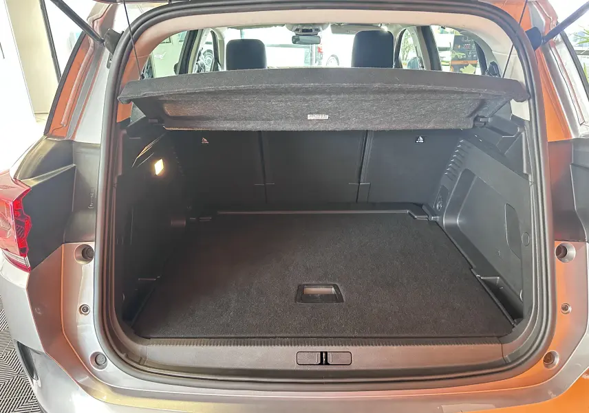 Coffre ouvert vu de l'arrière du Citroën C5 Aircross 2024 gris Artense avec banquette arrière et cache-bagages visible.