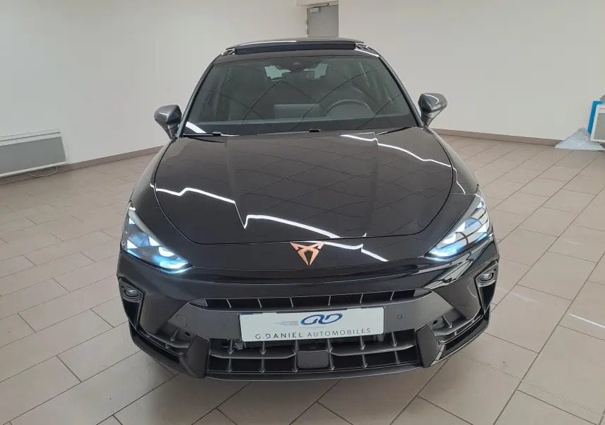 Vue avant d'une CUPRA Leon 2025 noir minuit avec projecteurs Matrix LED allumés et toit ouvrant panoramique visible.