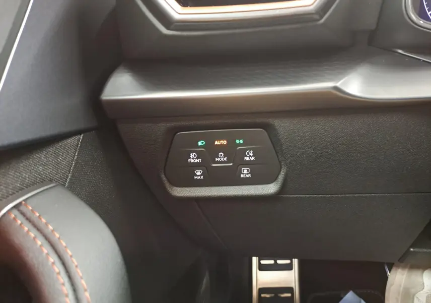 Détail du tableau de bord côté gauche avec commandes d’éclairage et matériaux noirs texturés dans la CUPRA Leon 2025.