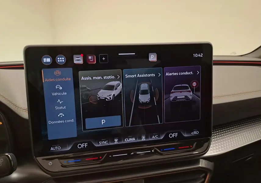 Écran tactile intérieur du tableau de bord du CUPRA Leon 2025 montrant les aides à la conduite et la climatisation.