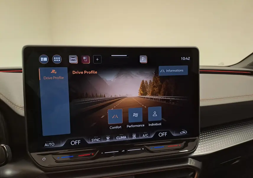 Vue intérieure du tableau de bord du CUPRA Leon 2025, écran tactile affichant les modes de conduite avec finition noire et surpiqûres rouges.