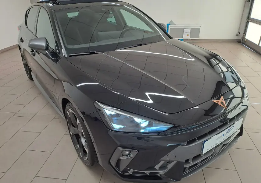 Vue 3/4 avant droite d'une CUPRA Leon 2025 Noir Minuit avec projecteurs Matrix LED et toit ouvrant panoramique.