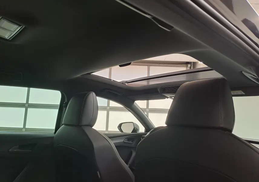 Vue intérieure arrière montrant le toit ouvrant panoramique et les sièges noirs du CUPRA Leon Noir Minuit 2025.