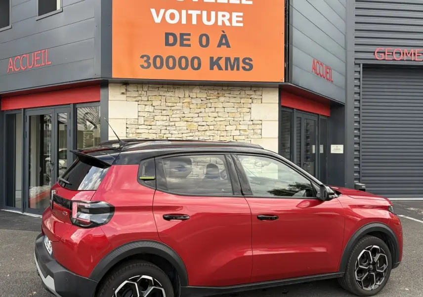 Vue latérale droite d'une Citroën C3 Turbo 100 BVM6 MAX rouge 2025 avec toit noir et jantes distinctives.