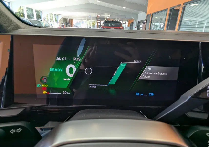 Vue intérieure du tableau de bord numérique du Renault Austral E-Tech 200 Esprit Alpine, affichage éco et niveau carburant faible.