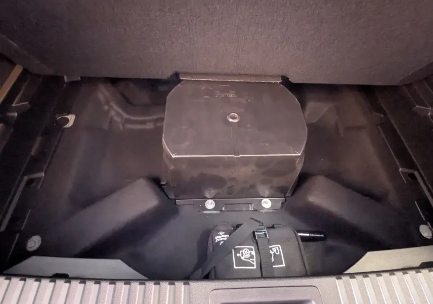 Coffre ouvert montrant le compartiment de rangement sous plancher d’un Renault Austral E-Tech gris, détail intérieur.