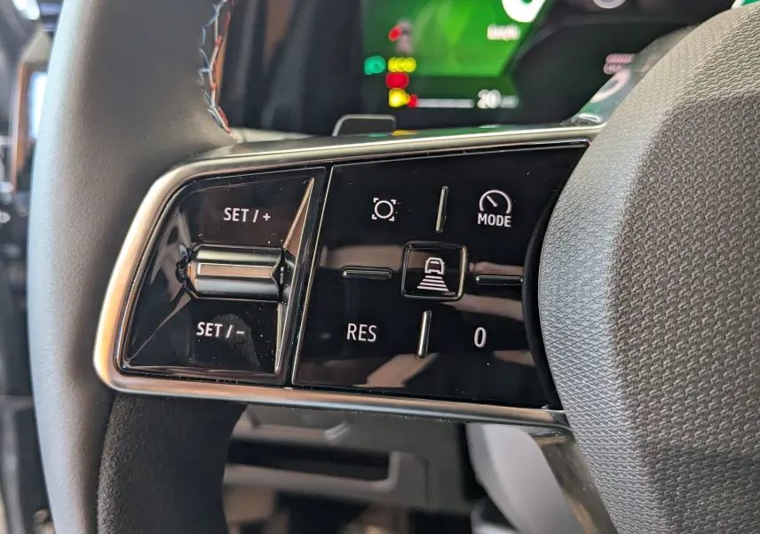 Gros plan sur les commandes de régulateur de vitesse au volant du Renault Austral E-Tech 200 gris schiste.