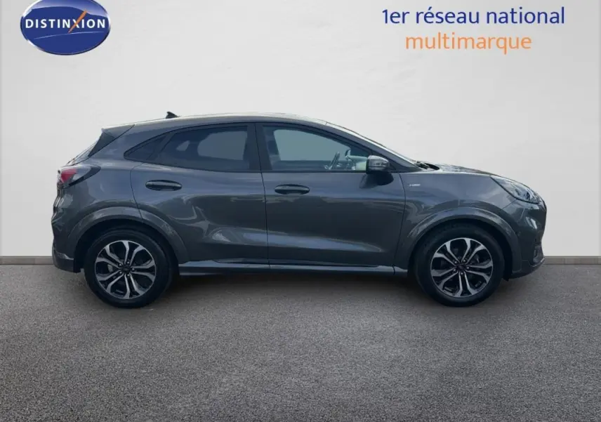 Vue de profil côté gauche d'un Ford Puma gris foncé avec jantes alliage 17 pouces sur fond neutre.