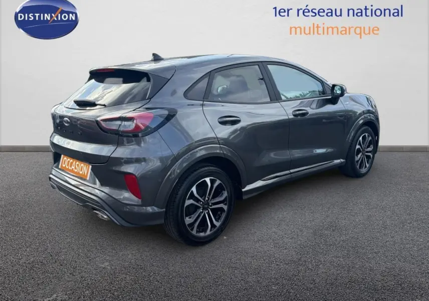 Ford Puma gris foncé vue 3/4 arrière droit, avec jantes alliage 17 pouces et feux arrière LED distinctifs.