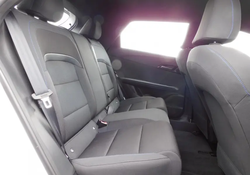 Vue latérale gauche de l'habitacle arrière du MG4 2023, sièges noirs avec surpiqûres bleues visibles.