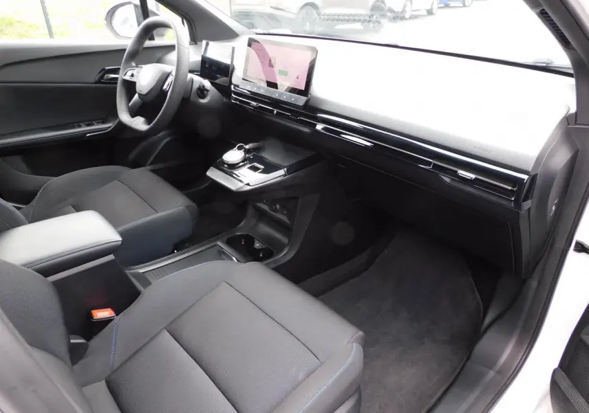 Intérieur avant du MG4 blanc 2023, vue côté passager mettant en valeur le tableau de bord épuré et l'écran tactile central.