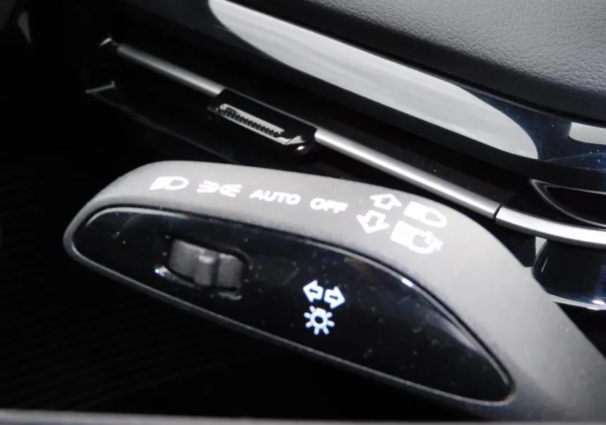 Gros plan sur la manette de commandes lumineuses noire dans l'habitacle du MG MOTOR MG4 blanc 2023.