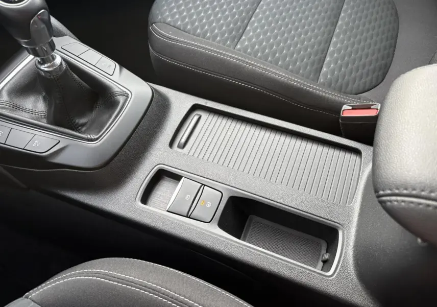 Vue rapprochée de la console centrale noire avec levier de vitesses manuelle et accoudoir du Ford Kuga 2024.