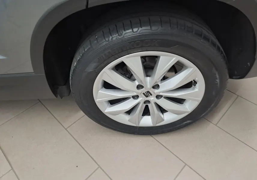 Gros plan sur la roue avant gauche d’un SEAT Ateca gris graphite avec jante alliage à dix branches.