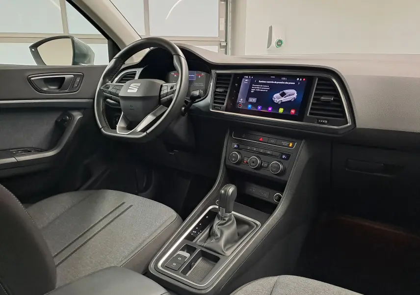 Vue intérieure côté conducteur du SEAT Ateca 2023, tableau de bord moderne avec écran tactile et volant multifonction.