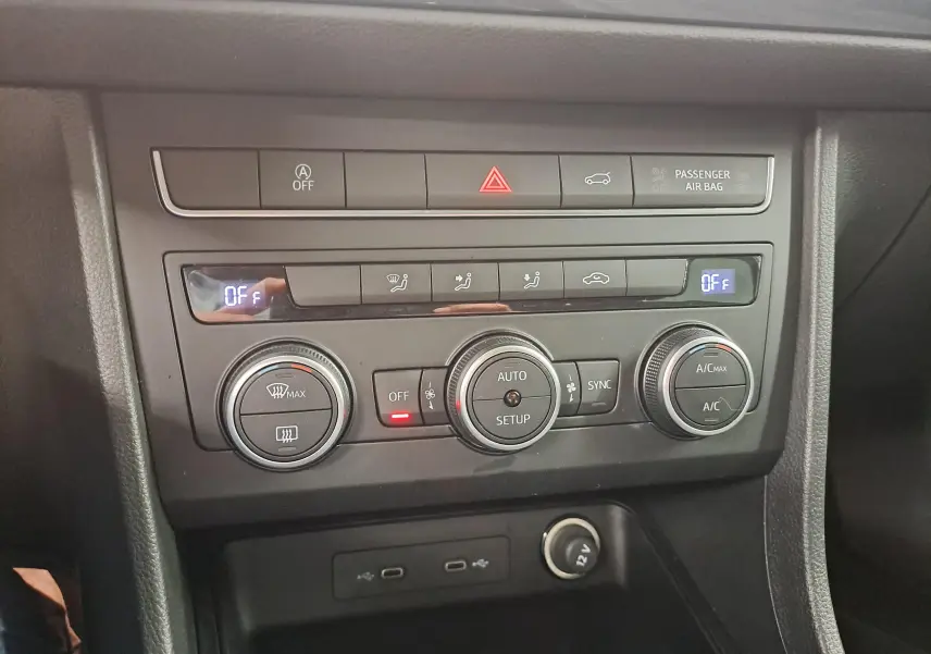 Vue rapprochée de la console centrale du SEAT Ateca 2023, montrant les commandes de climatisation et les ports USB.