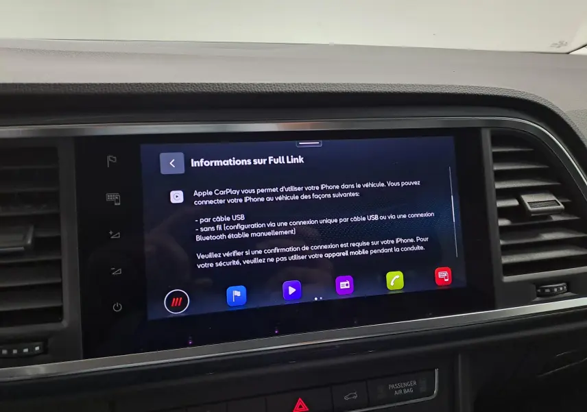 Écran tactile central du SEAT Ateca 2023 affichant les informations sur Apple CarPlay, entouré de la console noire.