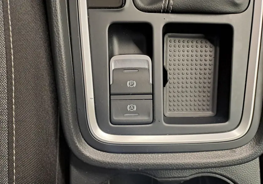 Gros plan sur la console centrale du SEAT Ateca 2023, avec boutons de frein à main électronique et auto hold, finition noire.