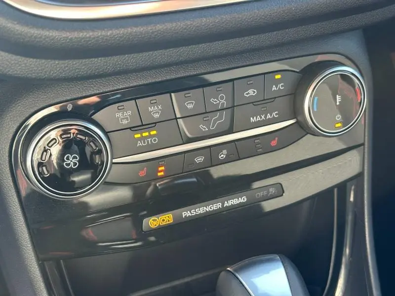 Gros plan sur la console centrale du Ford Puma 2023 gris Solar, montrant les commandes de climatisation et chauffage.