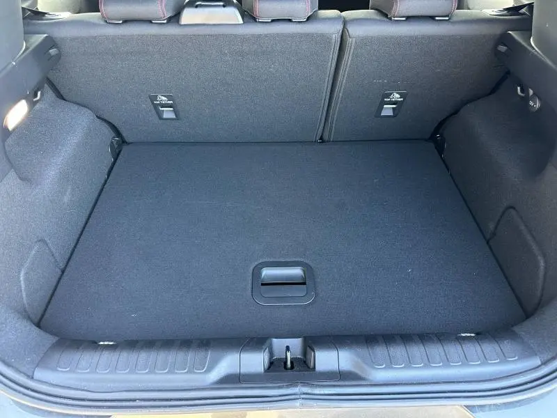 Vue plongeante sur le coffre spacieux et propre du Ford Puma 2023 gris Solar Métallisé, avec banquette arrière rabattue partiellement.