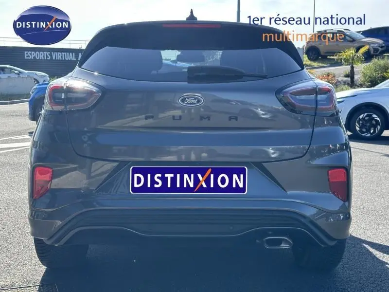 Vue arrière d'un Ford Puma 1.0 EcoBoost 155ch mHEV ST-Line gris Solar métallisé avec échappement visible côté droit.