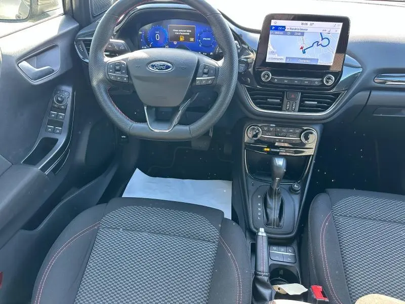 Vue intérieure avant du Ford Puma 2023, tableau de bord avec écran tactile et volant multifonction noir.