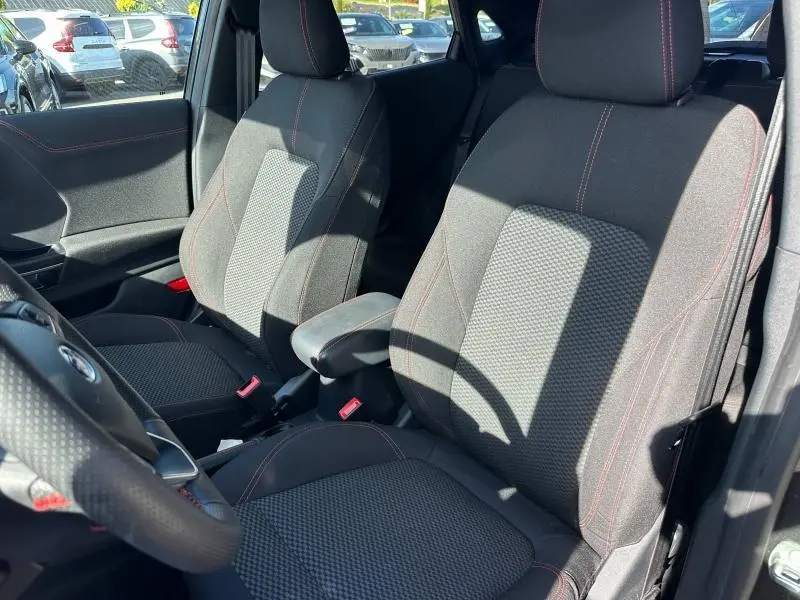 Vue intérieure rapprochée des sièges avant gris foncé avec surpiqûres rouges du Ford Puma 2023 ST-Line.