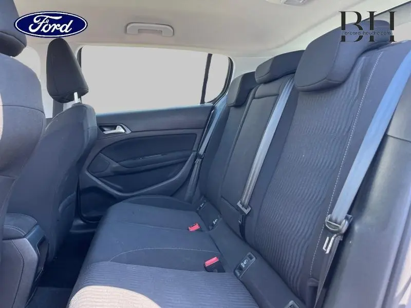 Vue intérieure arrière droite des sièges noirs d'une Peugeot 308 2016 avec ceintures et appuie-têtes visibles.