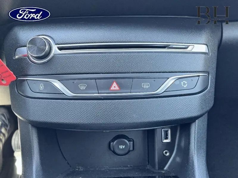 Détail de la console centrale noire avec commandes de verrouillage, feux et prise 12V d'une Peugeot 308 gris Artense.