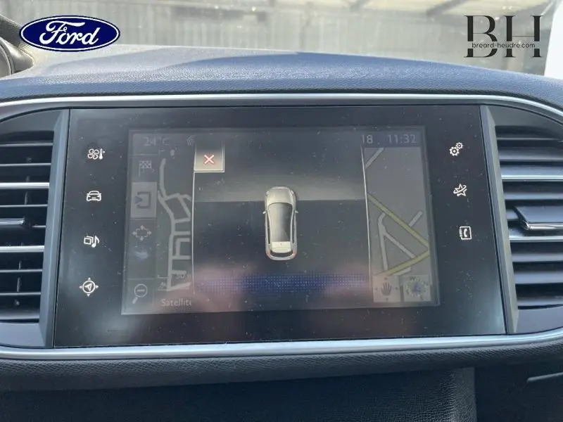 Écran tactile central de la Peugeot 308 gris Artense montrant la navigation et l'aide au stationnement.