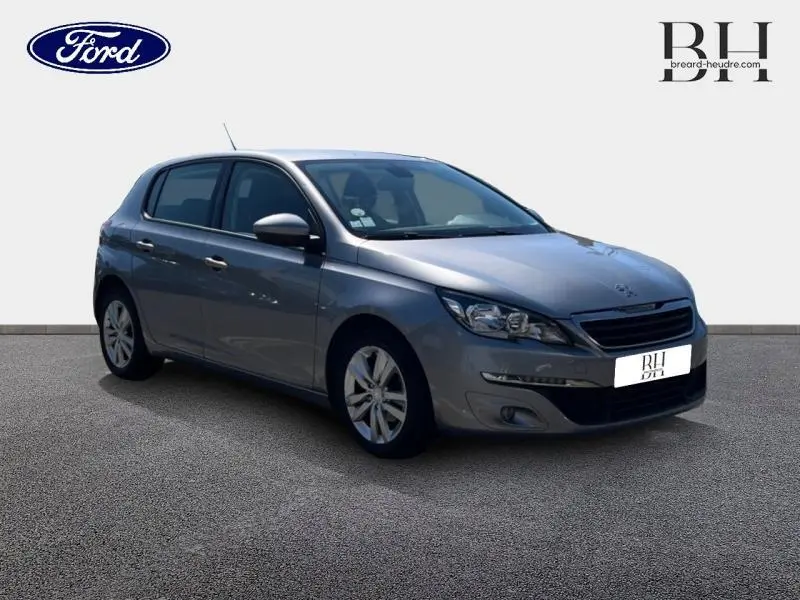 Peugeot 308 gris Artense vue 3/4 avant droit, jantes alliage et feux avant LED visibles.