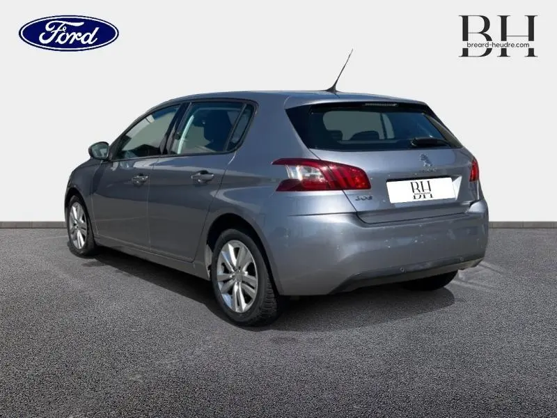 Peugeot 308 gris Artense vue 3/4 arrière droit, mettant en valeur ses feux arrière LED et jantes alu.