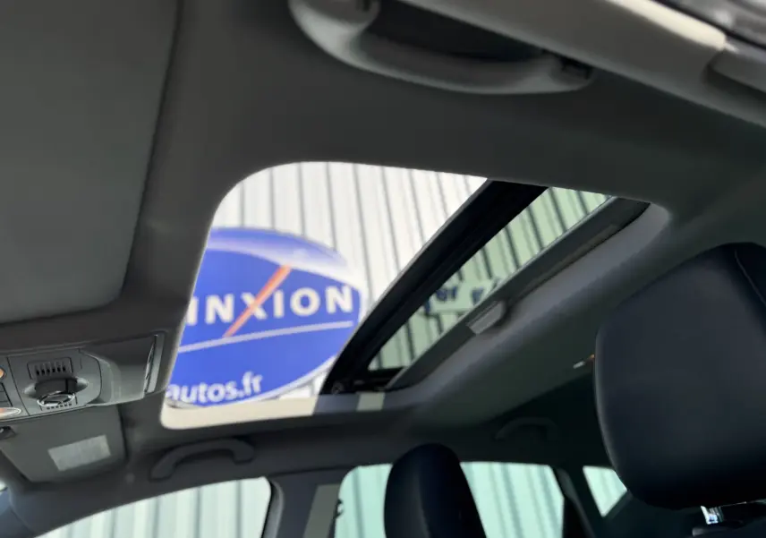 Vue intérieure du toit ouvrant panoramique du SEAT Leon 1.8 TFSI blanc de 2014, avec ciel visible à travers le verre.