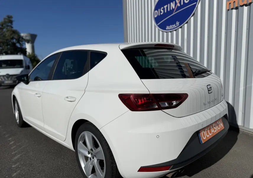SEAT Leon blanc vue 3/4 arrière droit, avec feux arrière LED et jantes alliage 17 pouces visibles.