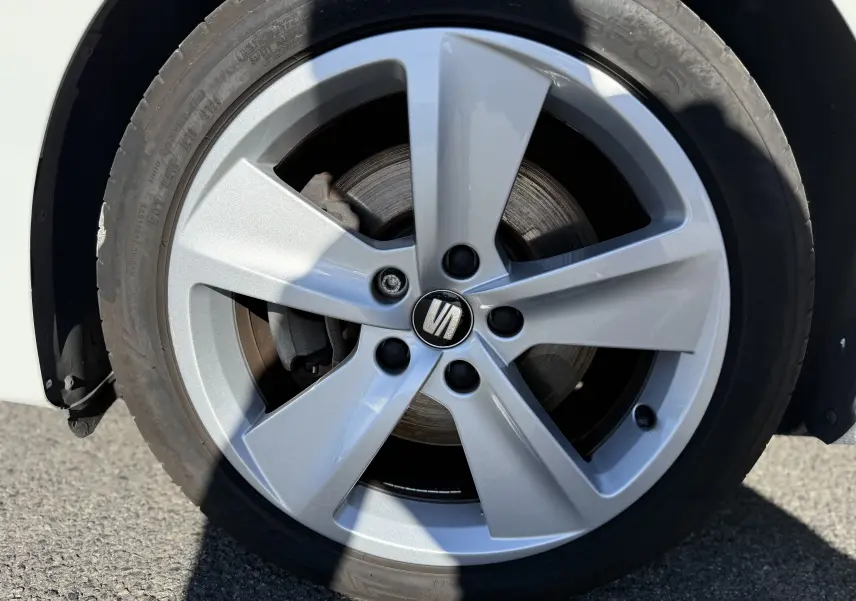 Gros plan sur la jante alliage argentée 17 pouces d'une SEAT LEON 1.8 TFSI blanche, avec logo central visible.