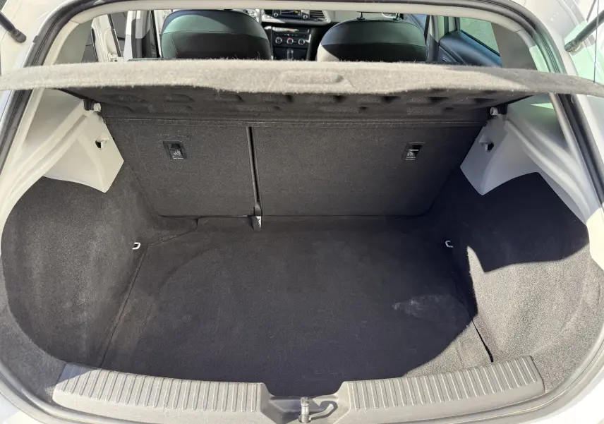 Coffre ouvert vu de l'arrière d'une SEAT LEON blanc 2014, intérieur noir avec banquette arrière visible.