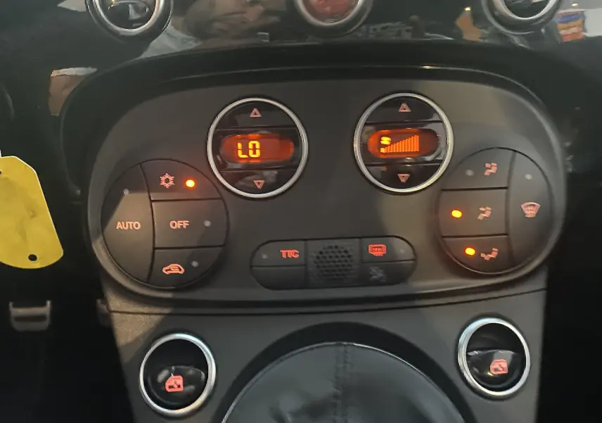 Détail du tableau de bord et commandes de climatisation automatique de l'Abarth 595 noire de 2018.