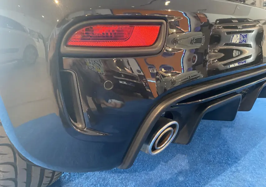 Gros plan sur le feu arrière droit et la sortie d’échappement d’une ABARTH 595 noire, finition brillante.