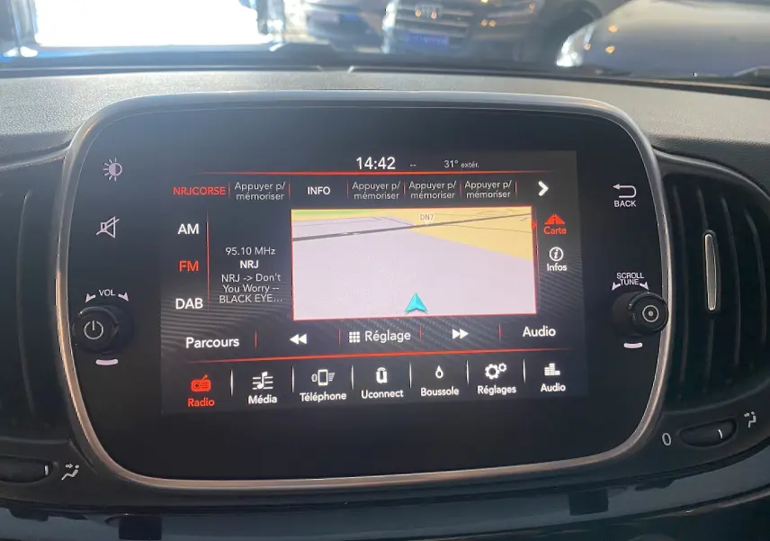 Écran tactile GPS du tableau de bord de l'Abarth 595 noir, affichant la radio et la navigation en vue frontale.