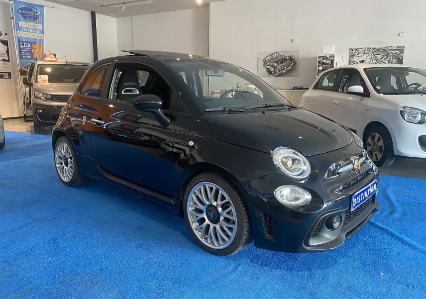 ABARTH 595 noir en 3/4 avant droit, jantes alu 17 pouces et toit ouvrant visible en intérieur showroom.
