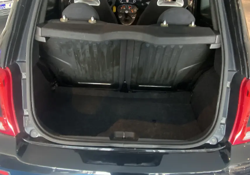 Coffre ouvert d'une ABARTH 595 noire vue de l'arrière, montrant l'intérieur du coffre et les sièges avant.