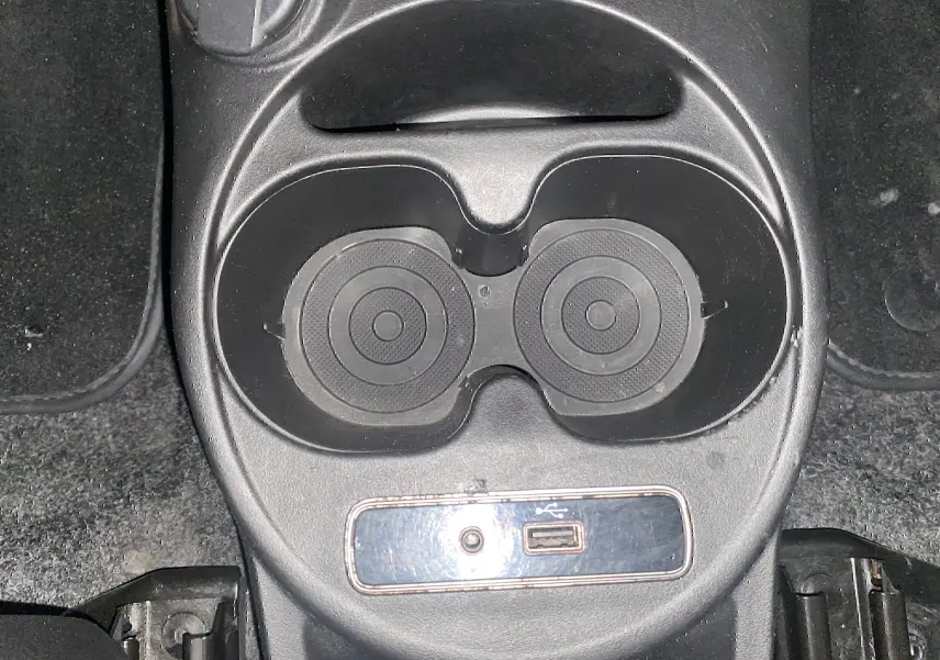 Gros plan sur les porte-gobelets et prise USB de la console centrale d'une ABARTH 595 noire de 2018.