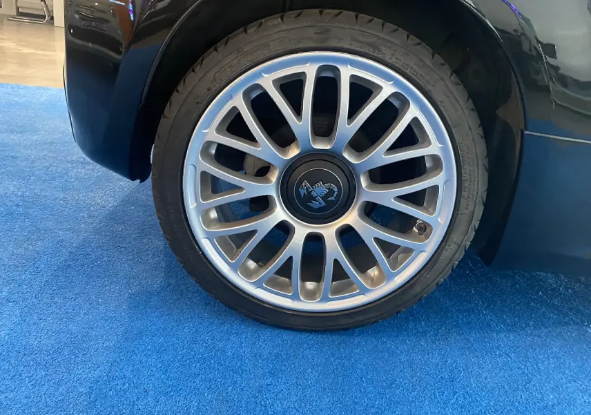 Gros plan sur la jante alu 17 pouces argentée avec logo Abarth d'une roue avant droite d'une ABARTH 595 noire.